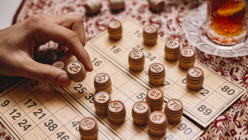 une main place des jetons sur des cartons de loto
